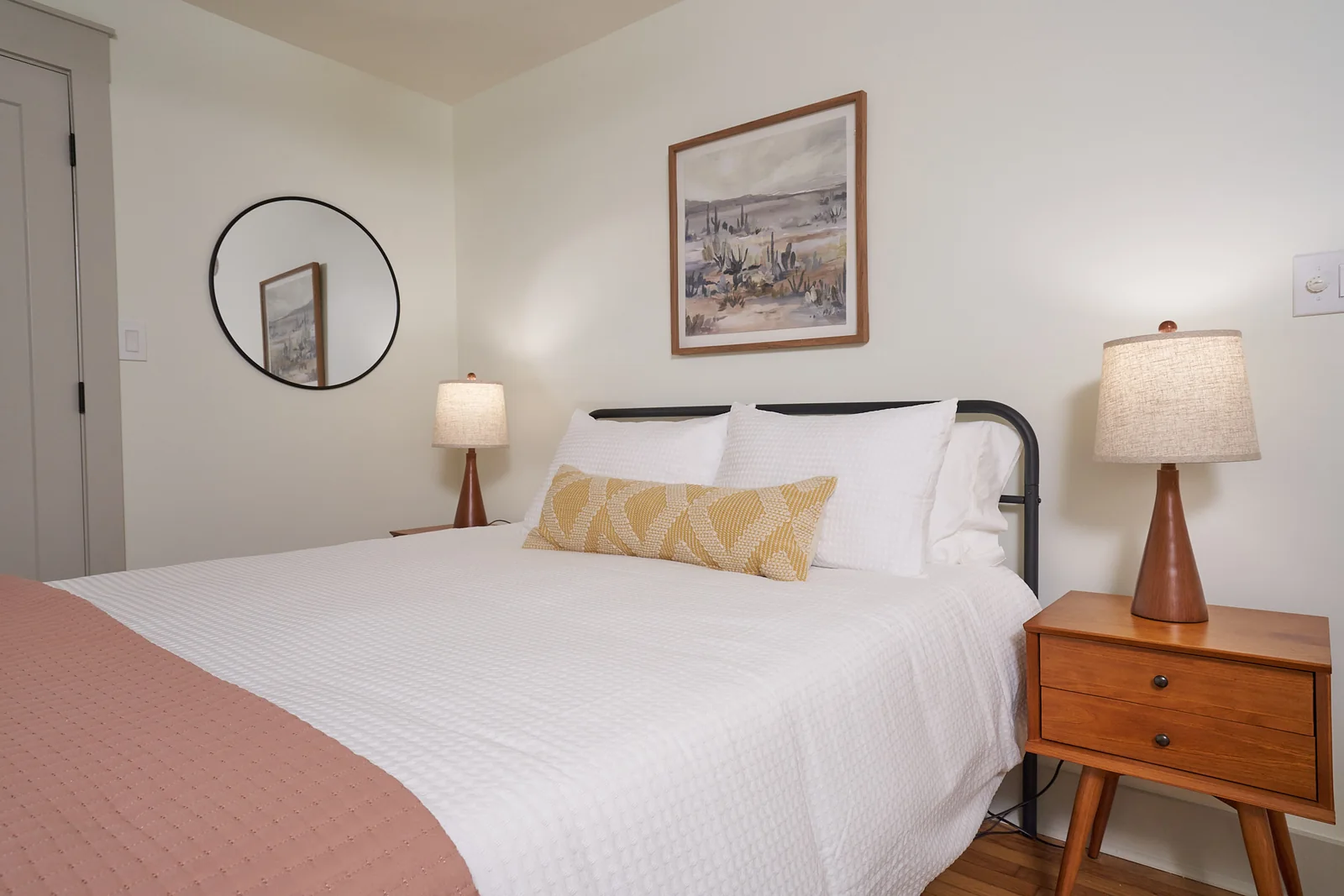 Queen bedroom with bedside lamps and botanical artwork